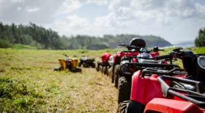 focus photography of ATV's falling in line on grass field