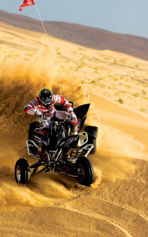person riding on ATV and drift on sand